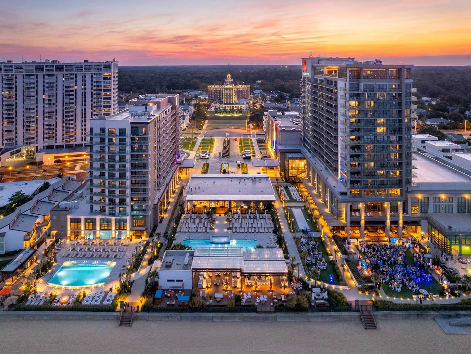 Night time drone shot showing all three Cavalier Resort properties from the ocean.