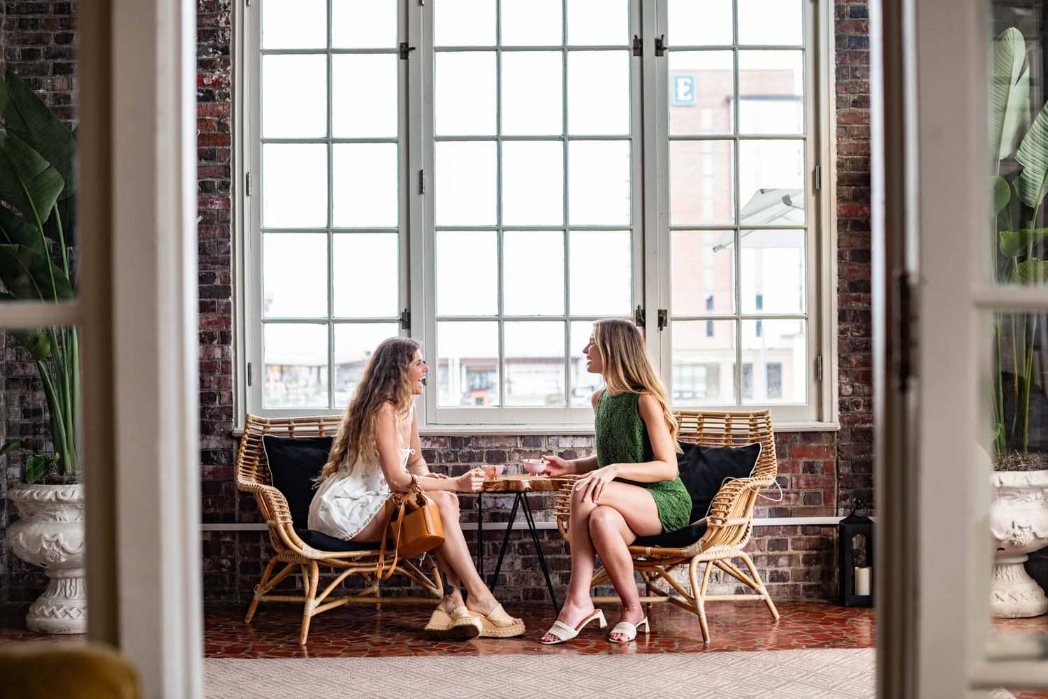 Two women sharing a laugh while drinking tea in The Cavalier loggia