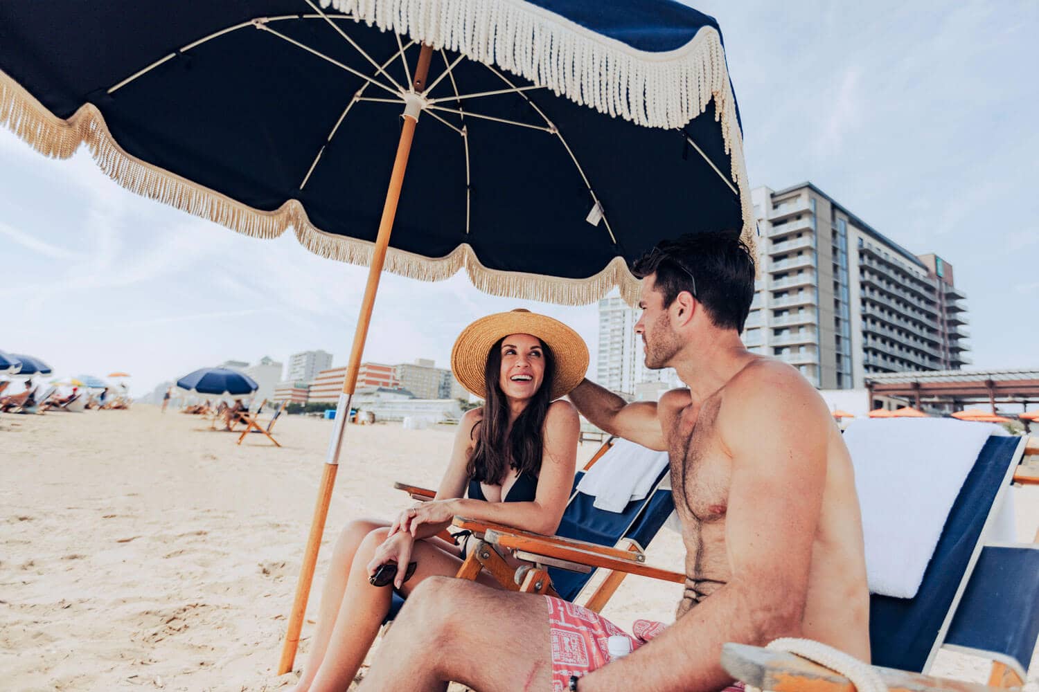 A couple using the chairs on the beach outside of the Cavalier Beach Club