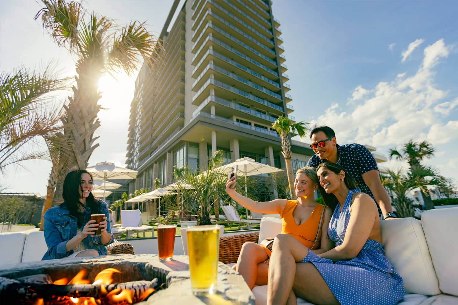 A group of friends enjoying drinks outside on the lawn of Tulu Seaside Bar and Grill