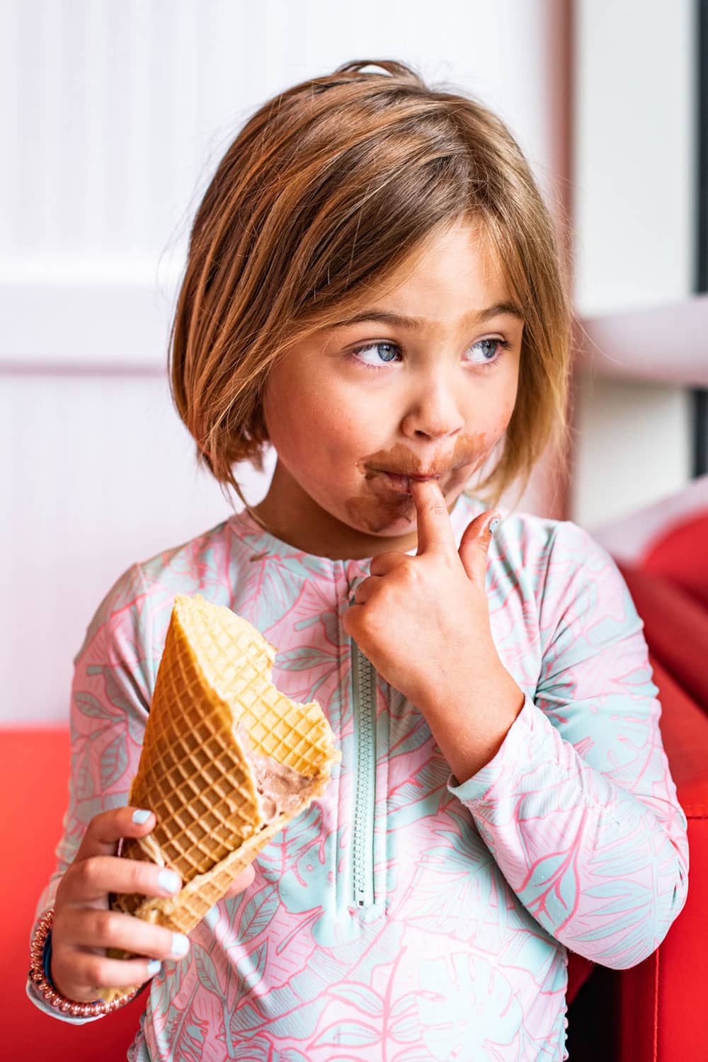 A young girl enjoying a cone of ice cream at We Scream Ice Cream & Starbucks