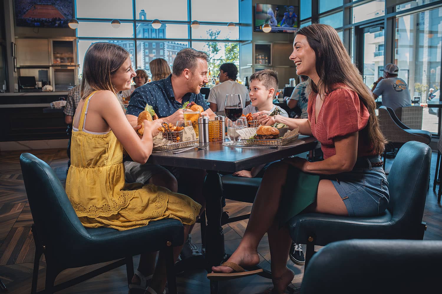 A family of four sitting at a table inside a restaurant.