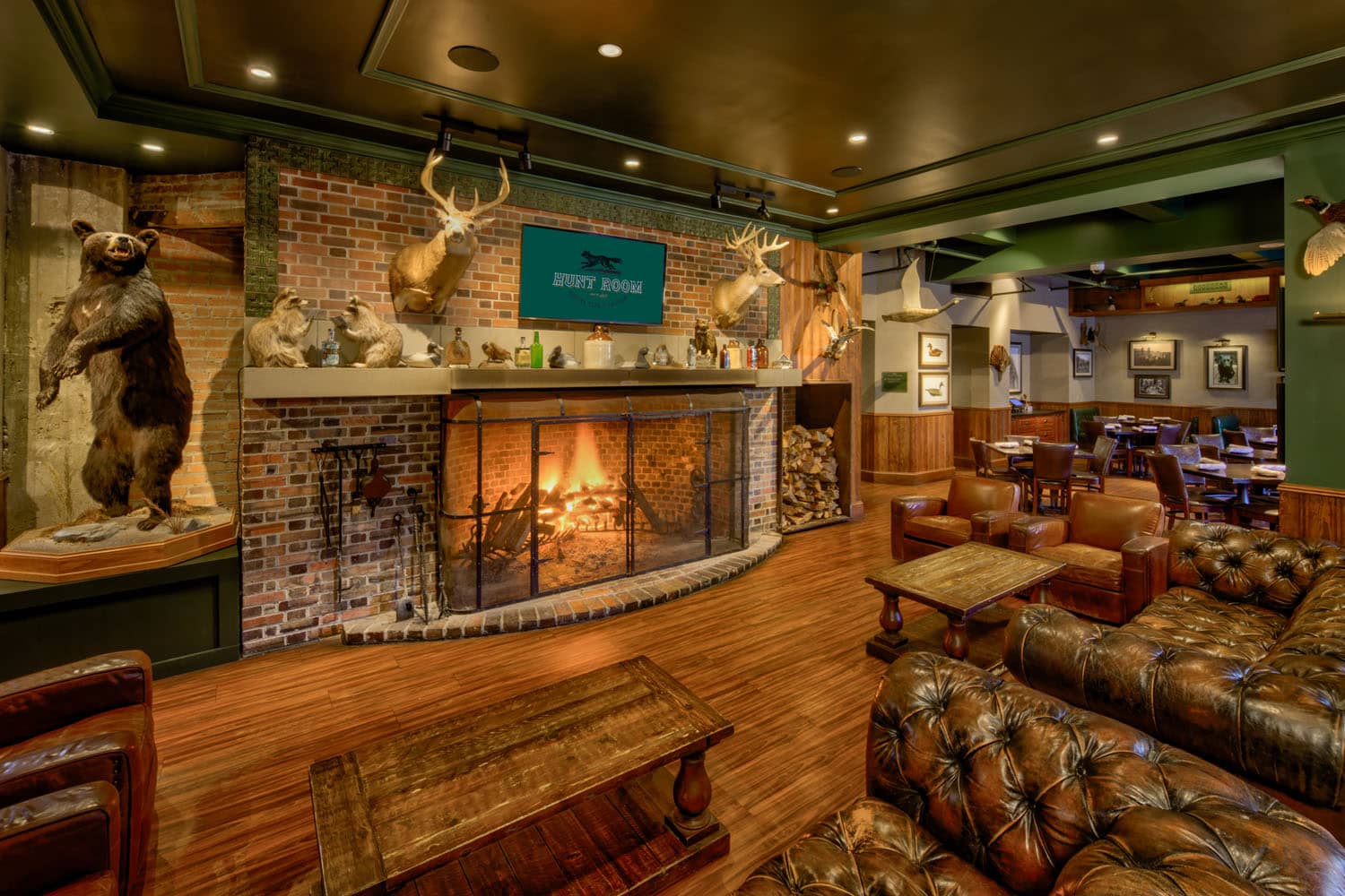 A fireplace and cozy lounge inside The Hunt Room