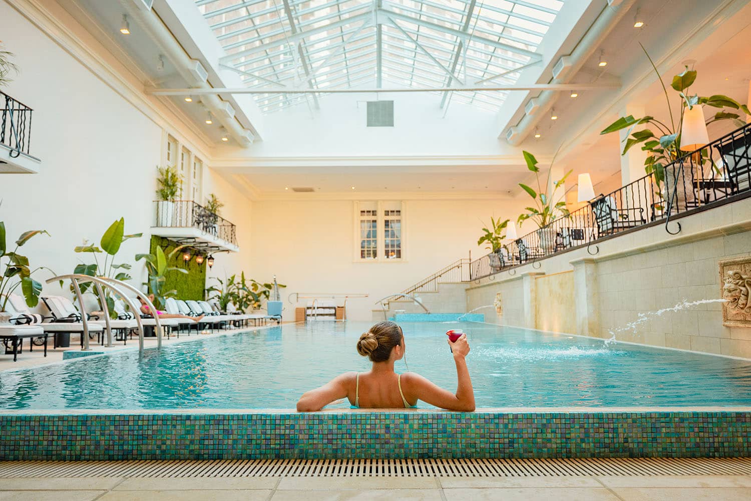 A woman sitting inside the indoor pool at The Historic Cavalier Hotel