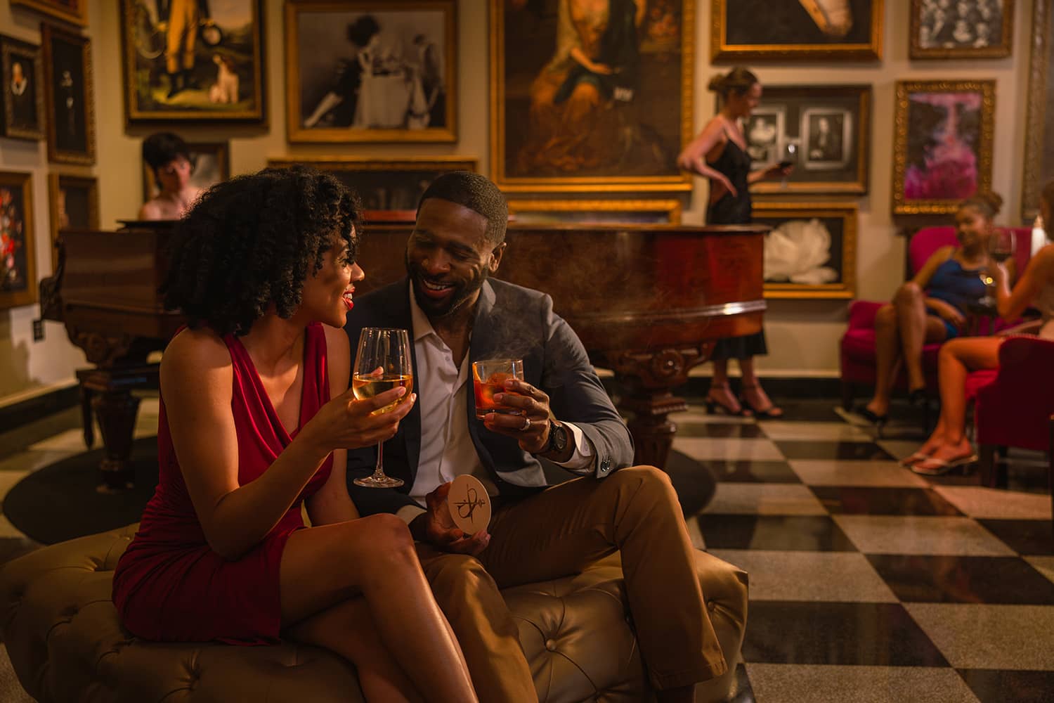 A couple sharing drinks inside a lobby
