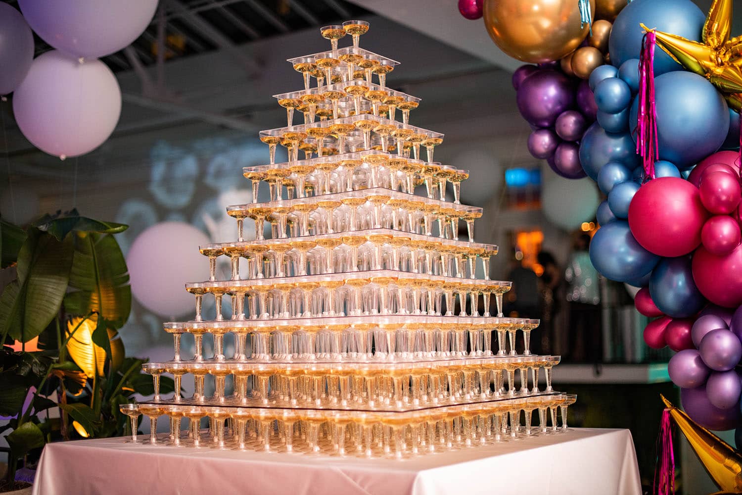 Dozens of champagne glasses stacked on top of each other on a decorated table