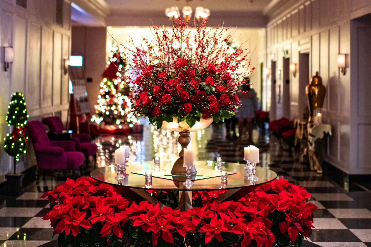 A decorated table with holiday flowers inside a hotel lobby