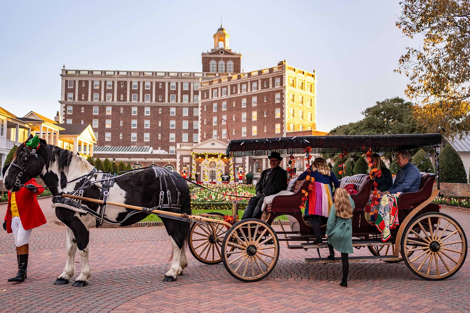 A family on a horse-drawn carriage in front of The Cavalier Hotel