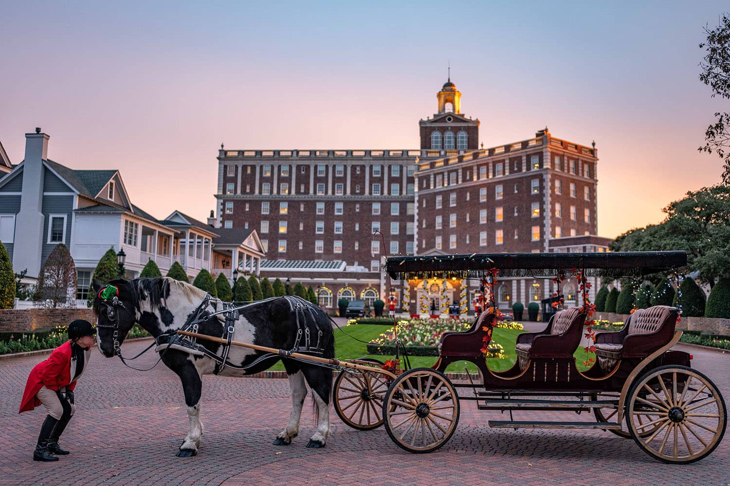 A horse-drawn carriage awaiting riders at the entrance of The Historic Cavalier Hotel