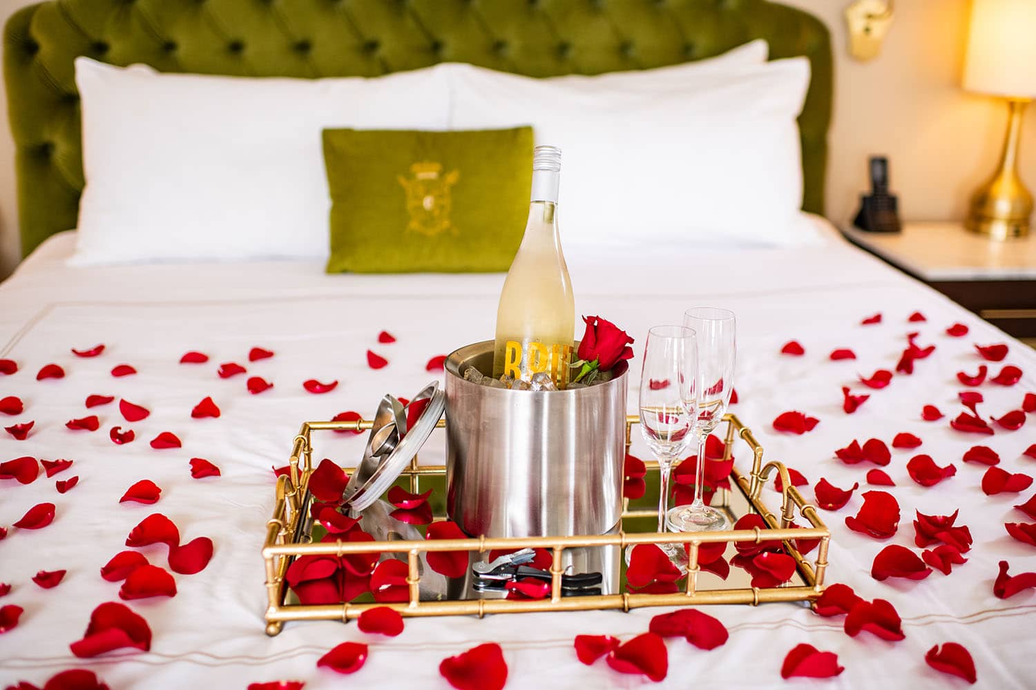 Rose petals and champagne on a bed at The Historic Cavalier Hotel.