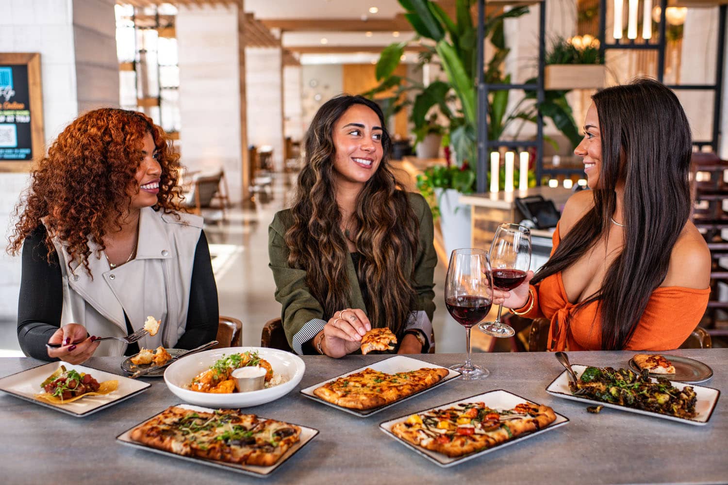 A group of women dining at the bar inside Tulu Seaside Bar & Grill