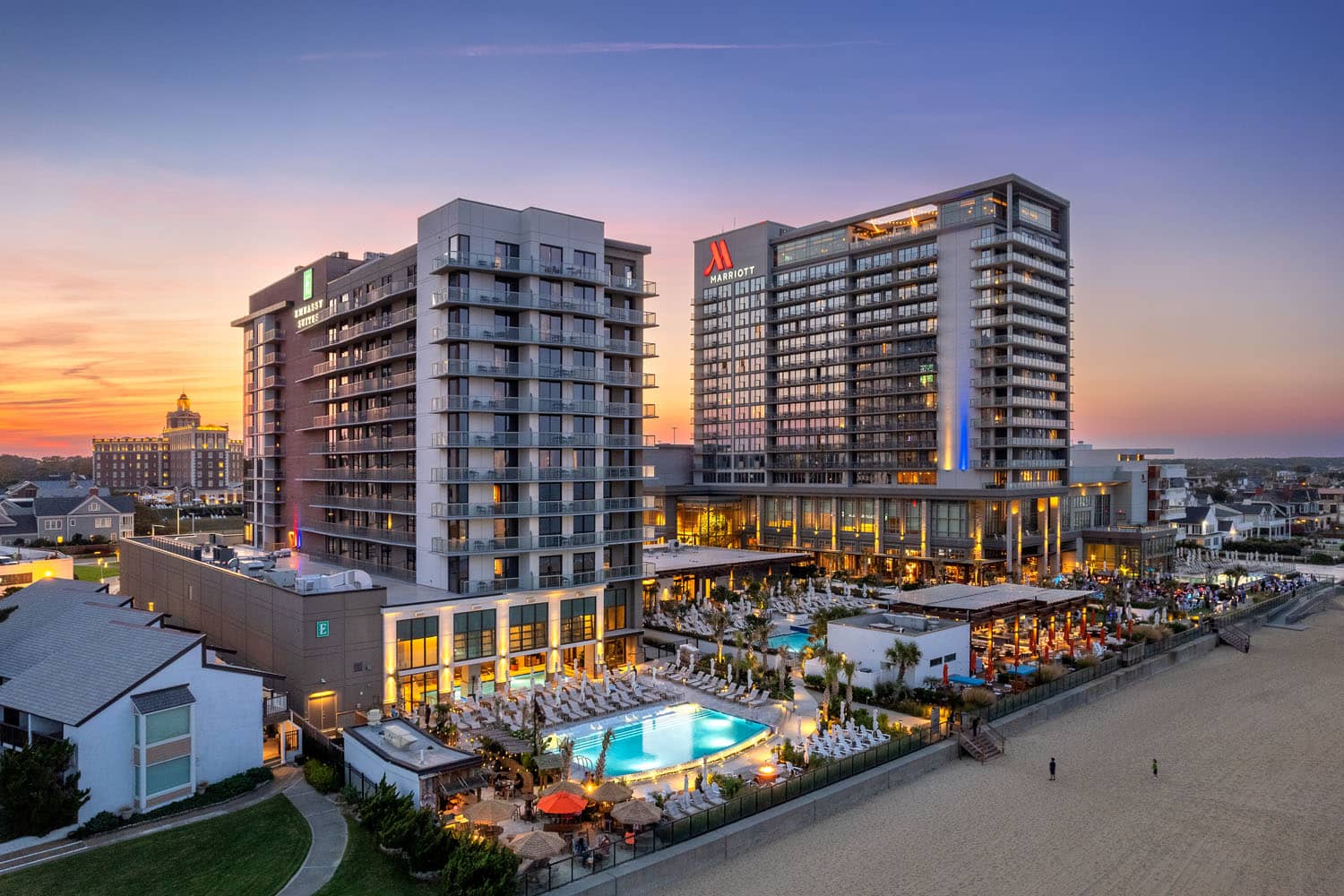 An aerial image at night of the Cavalier Resort Virginia Beach's three hotels
