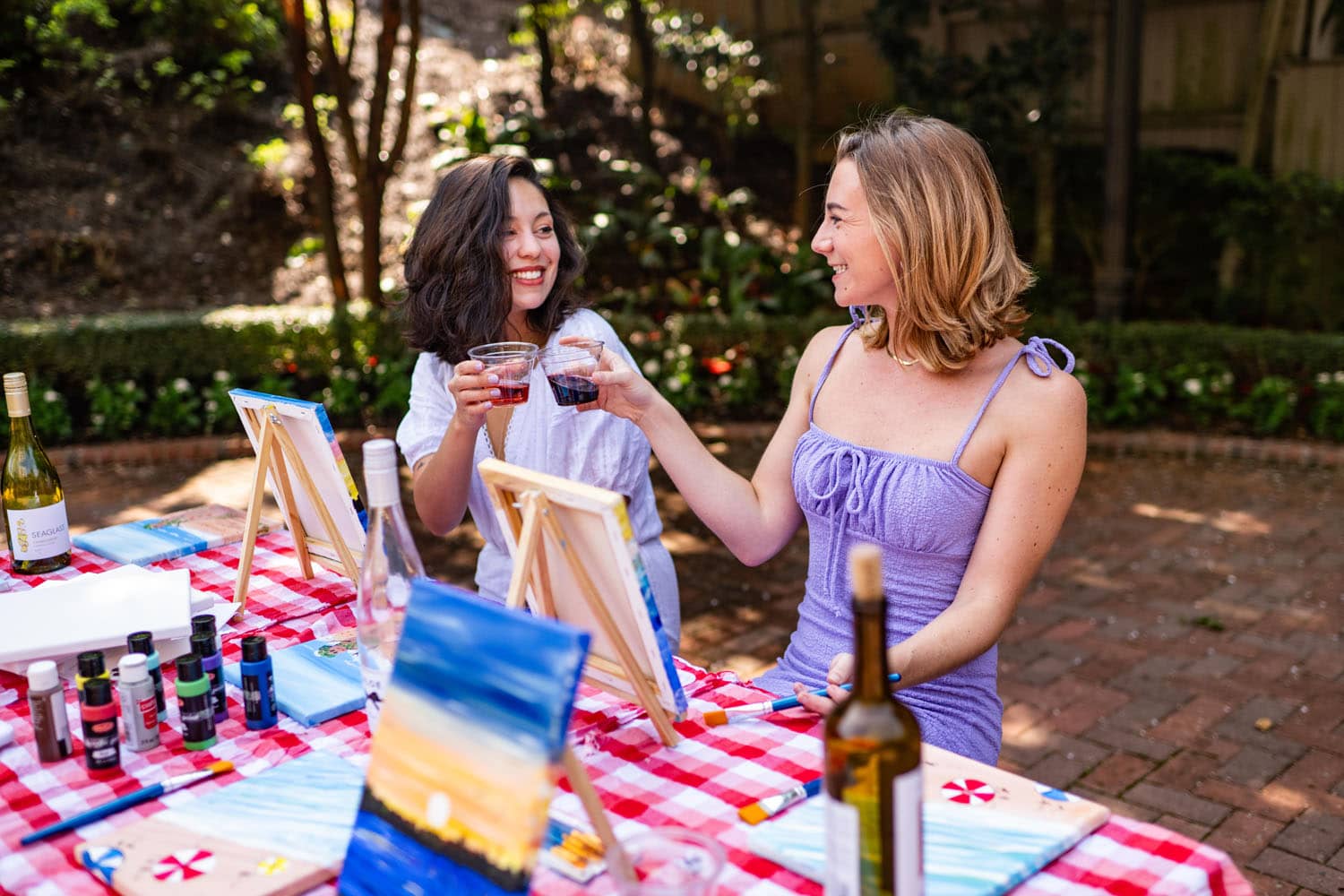 Two people drinking wine inside a garden
