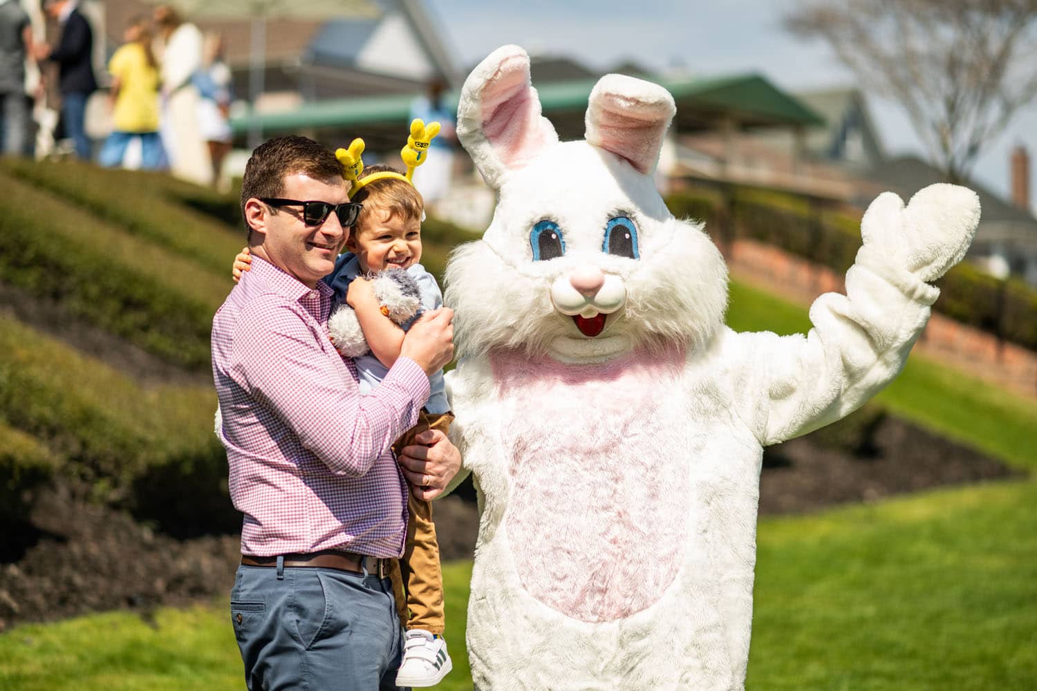 A father and daughter posing for a photo with the Easter Bunny