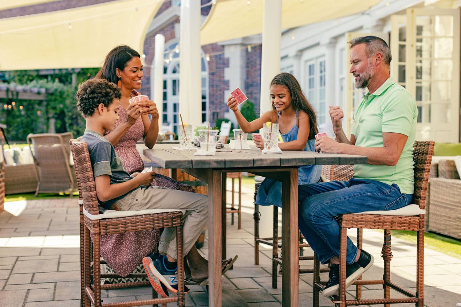A family playing a game of cards on an outdoor patio