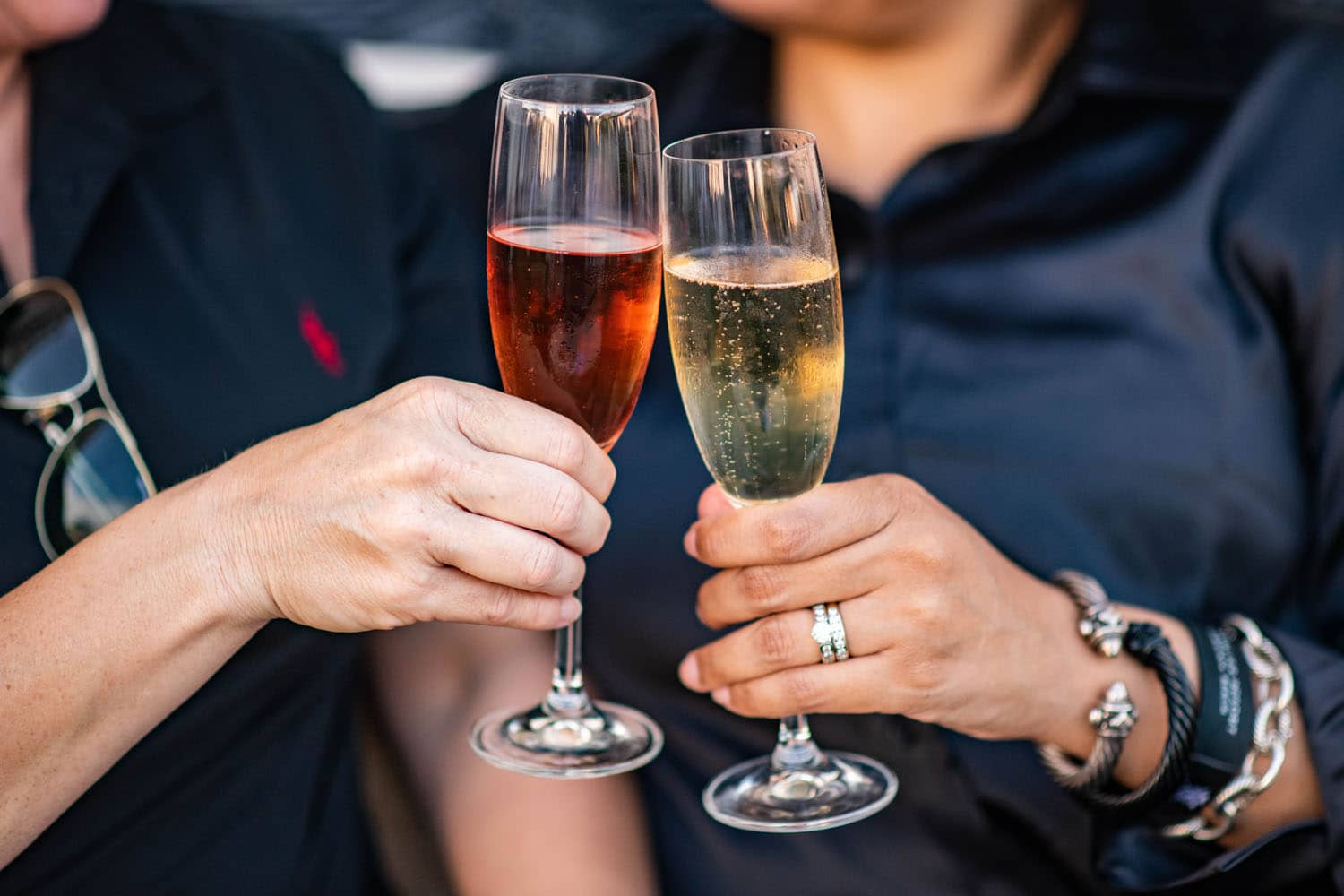 Champagne glasses being toasted by two hands