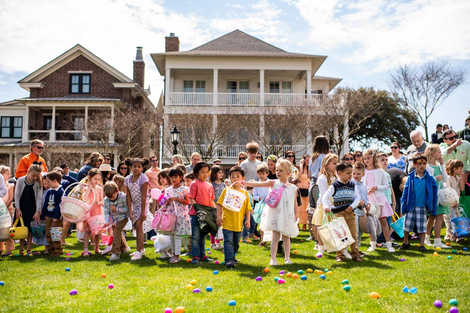 Children on a green lawn during an Easter egg hunt