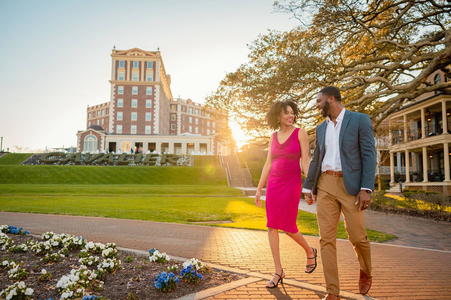 A couple holding hands and walking in front of The Historic Cavalier Hotel