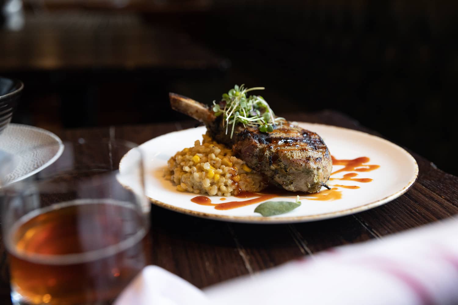 A grilled porkchop on a table at the Hunt Room restaurant