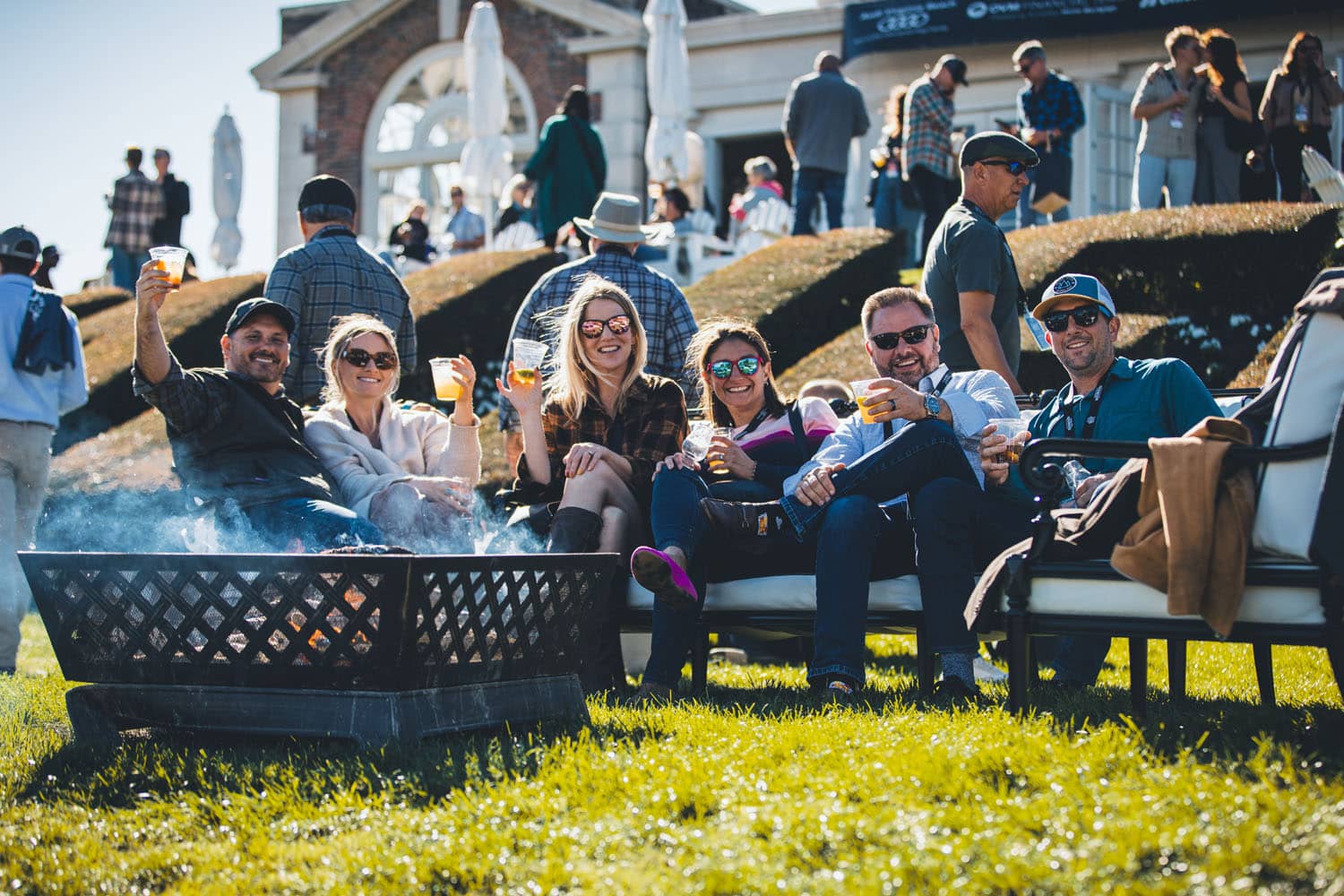 A group of people sitting at an outdoor fire pit
