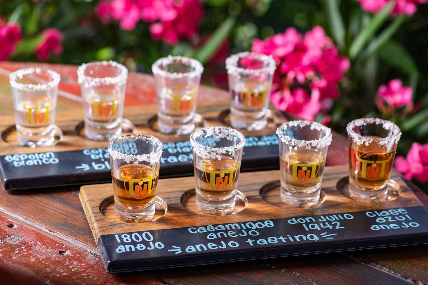 A flight of tequila drinks on a table at Tacos-N-Tequila