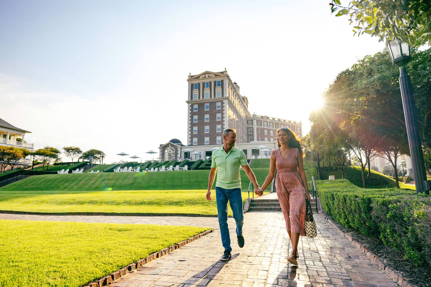 A couple holding hands walking outside The Historic Cavalier Hotel