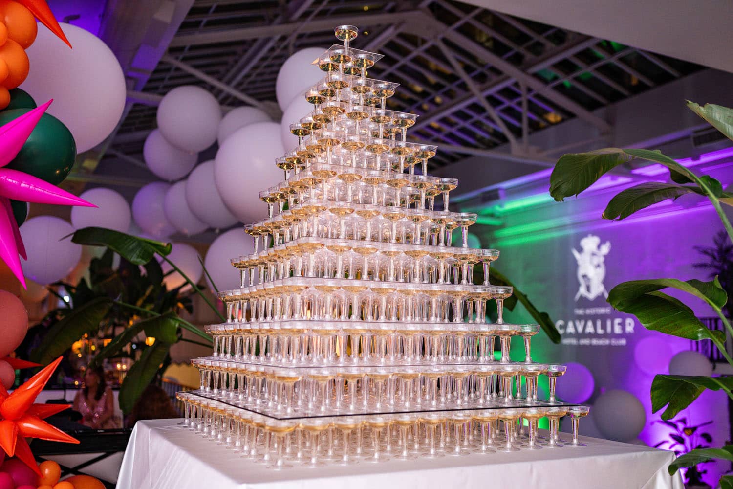 A table of champagne glasses stacked on top of each other at a party