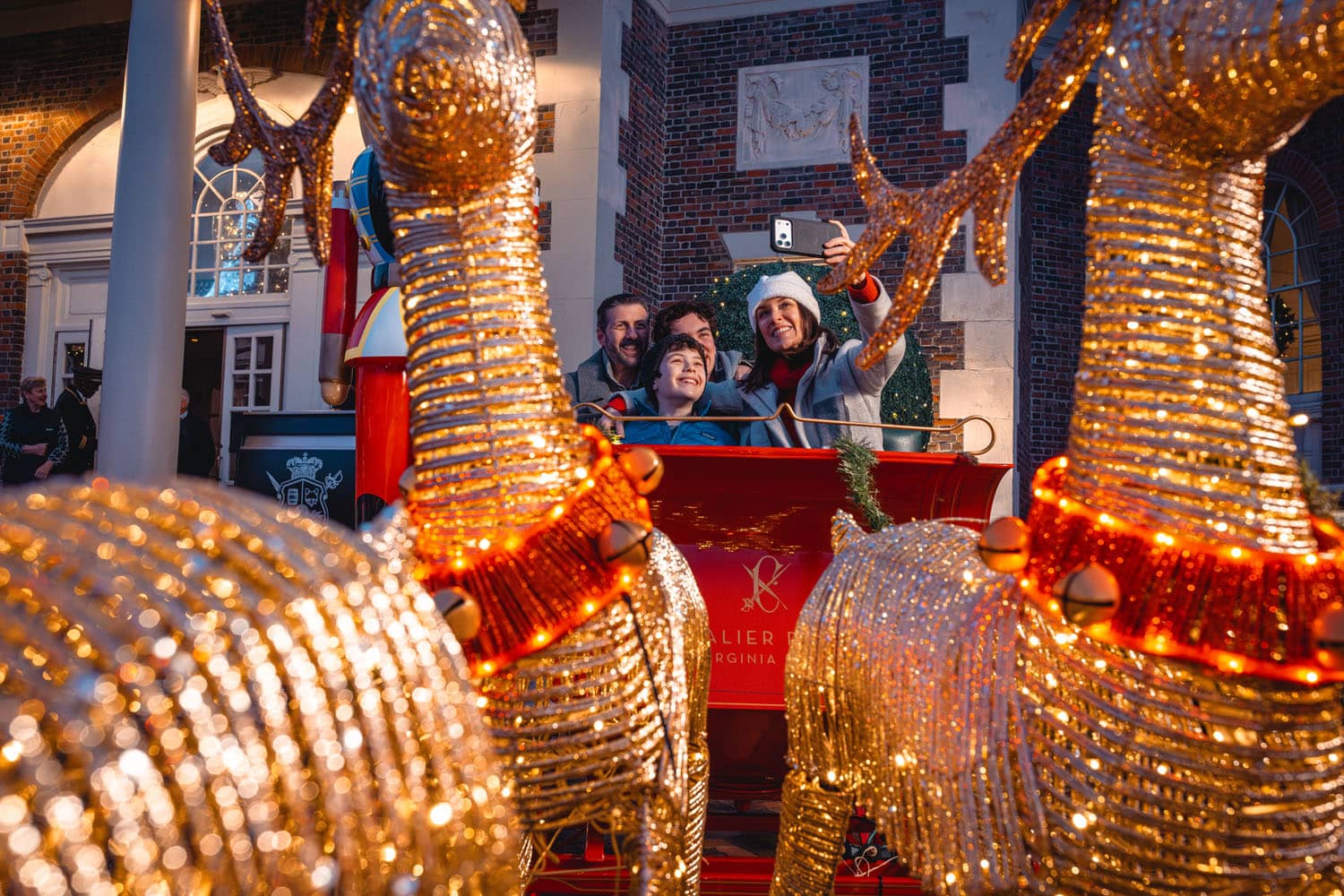 A family taking a selfie photo in Santa's Sleigh outside The Cavalier Hotel
