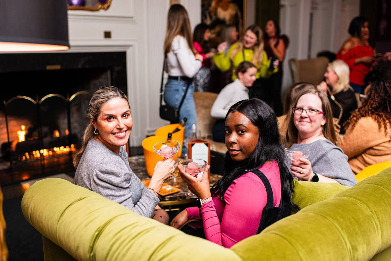 A group of women sitting inside a lounge drinking champagne