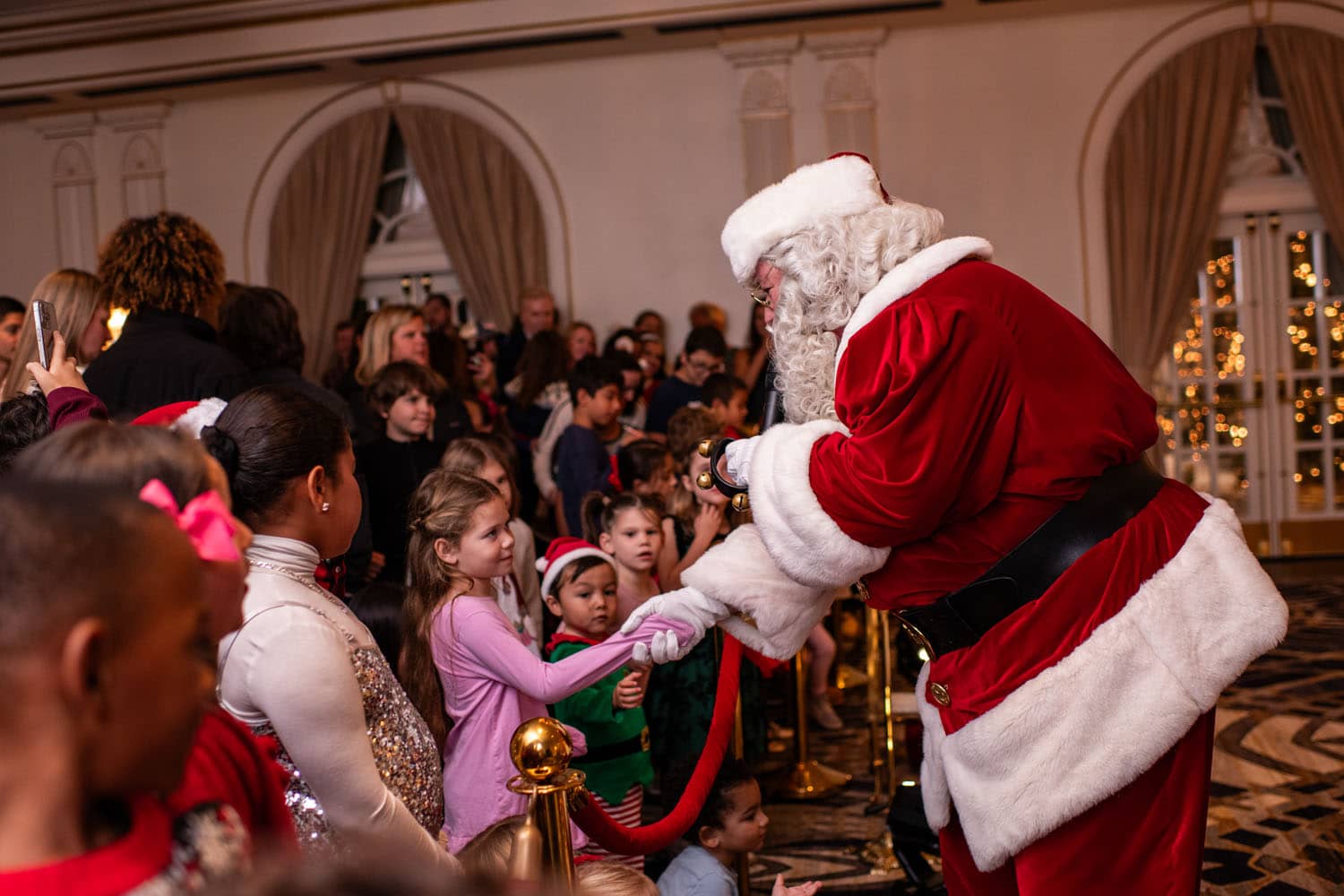 Santa greeting children at an indoor holiday event
