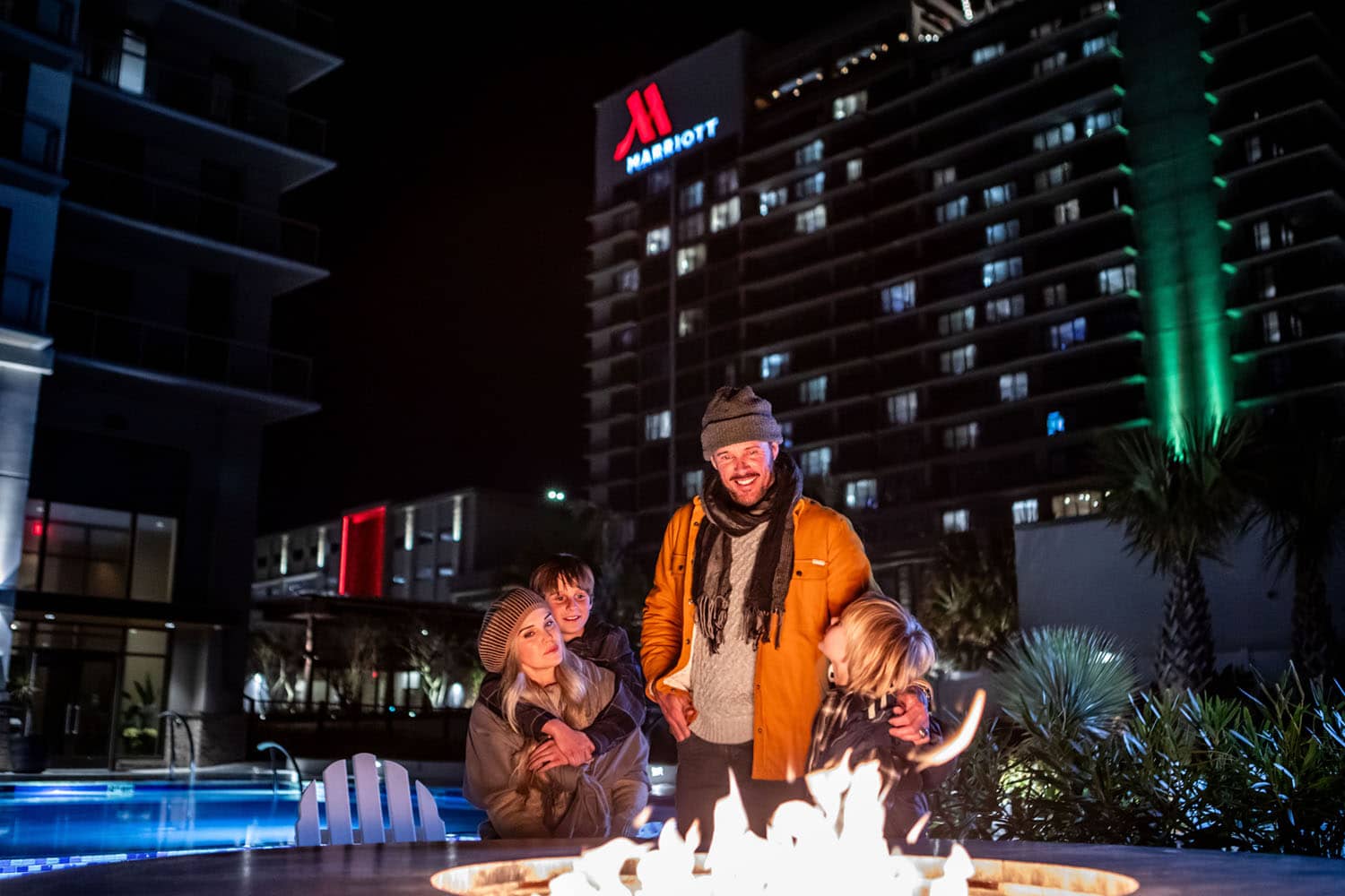 A family sitting at an outdoor firepit at the Cavalier Resort