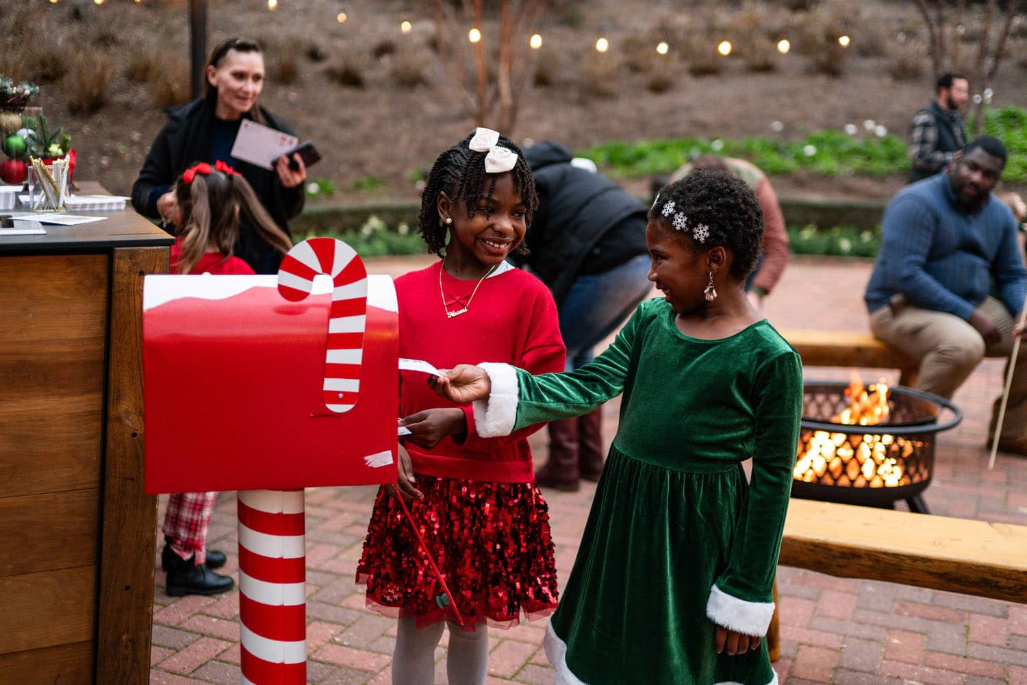 Two children placing letters to Santa in a mailbox