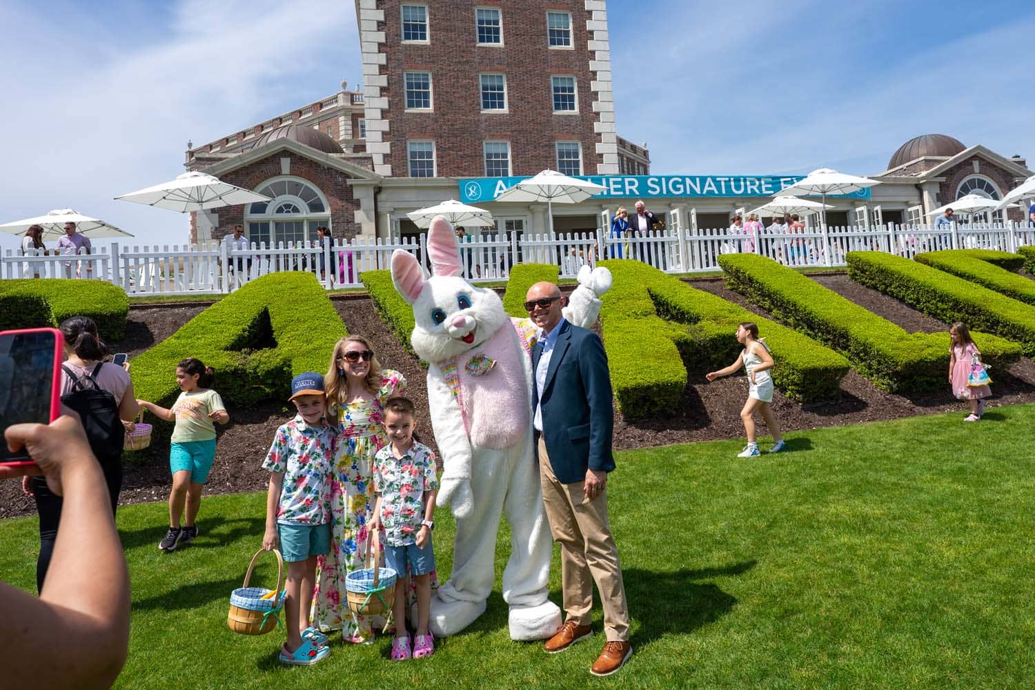 A family posing for a photo with the Easter Bunny outside