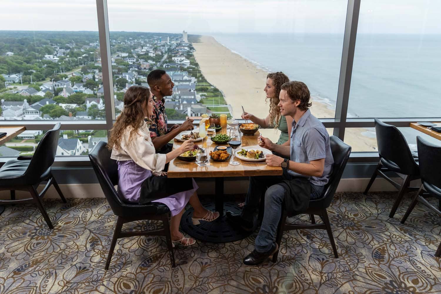 A group of people dining at Orion's Roof with sweeping ocean views