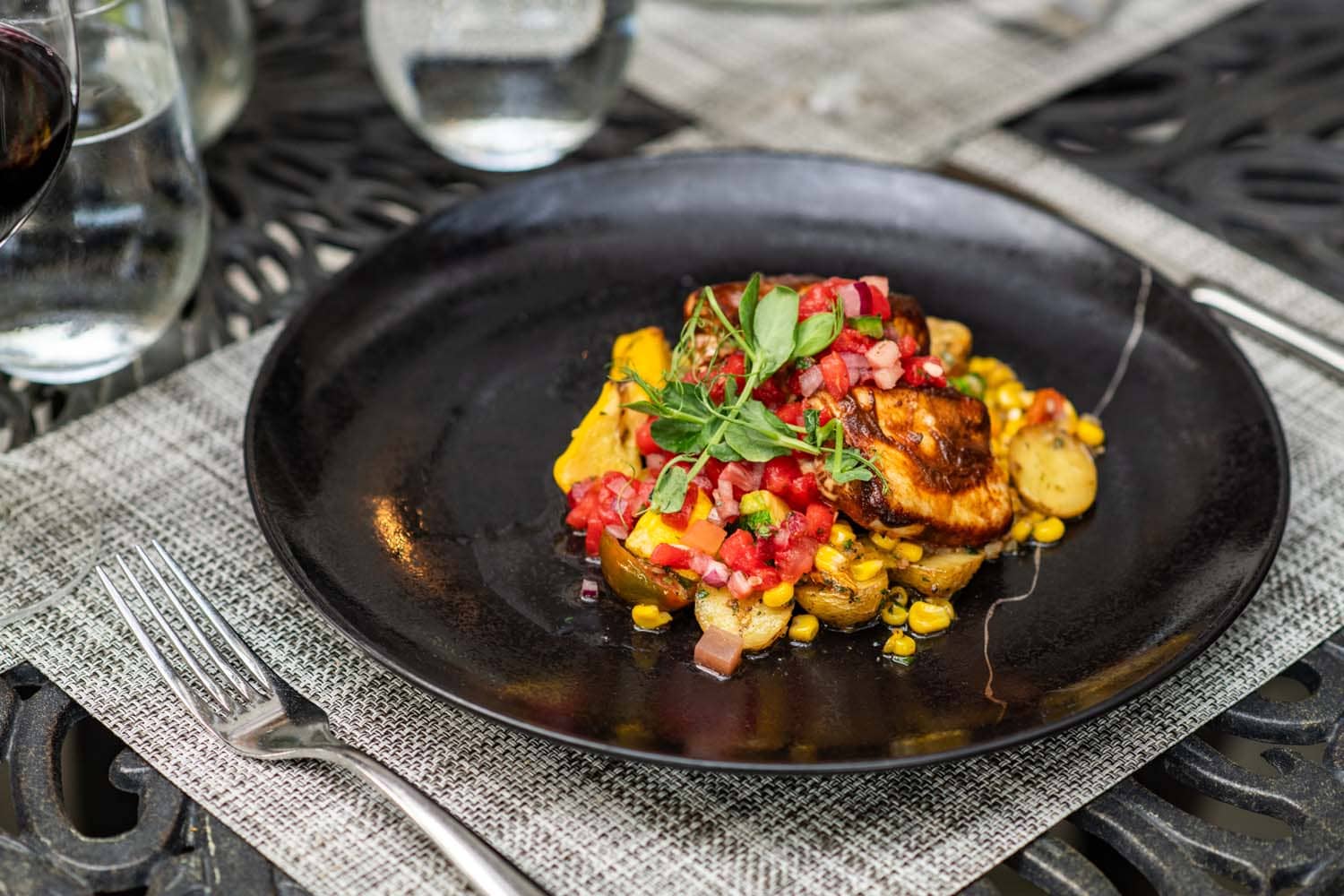 A plated salmon dish on a table at Becca Restaurant & Garden