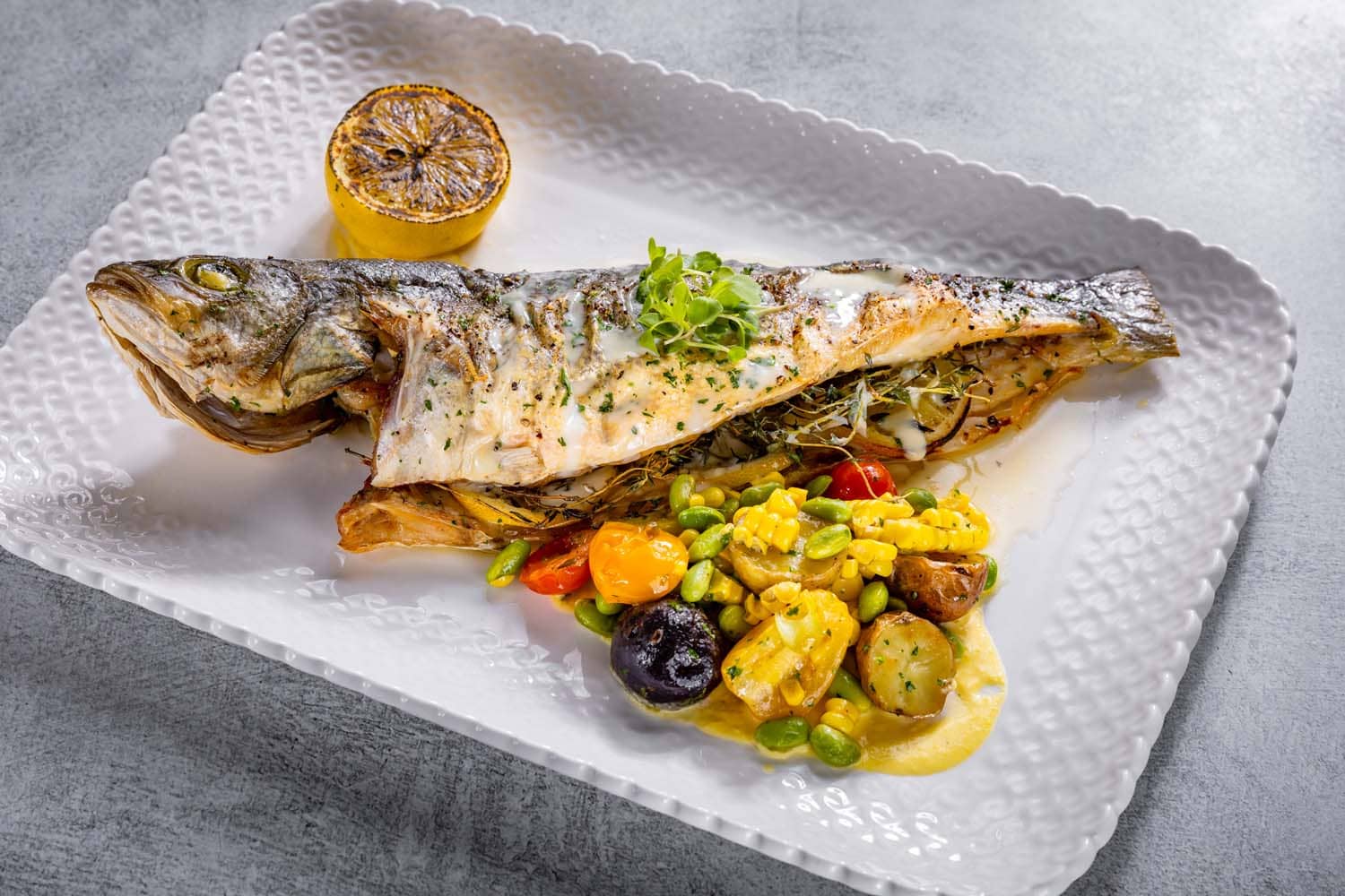 A whole fish special meal on a table at Becca Restaurant & Garden