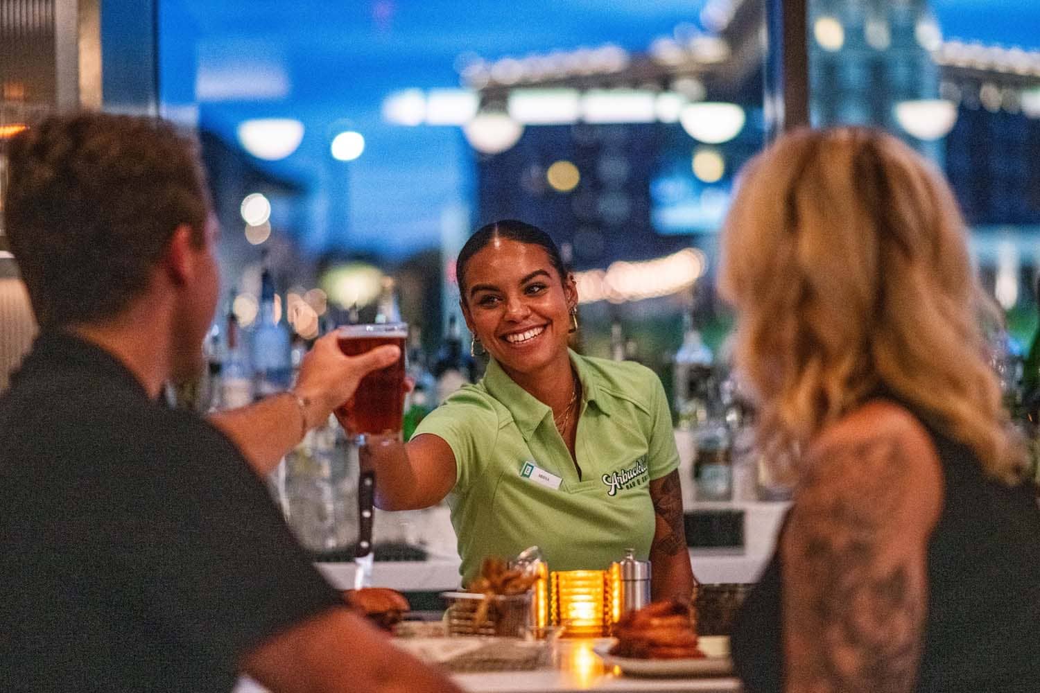 A bartender passing out drinks to guests at Arbuckle's Bar & Grill