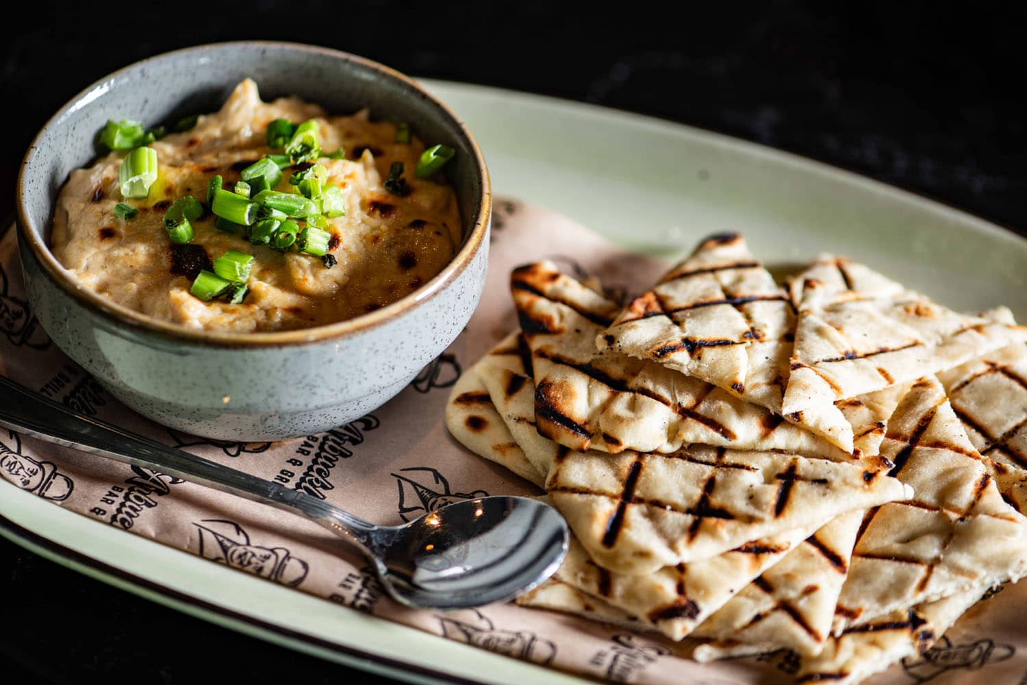 A plated flatbread dish on a table at Arbuckle's Bar & Grill