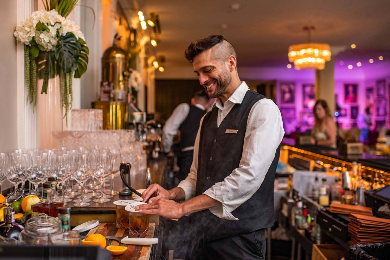 A bartender serving drinks inside The Raleigh Room