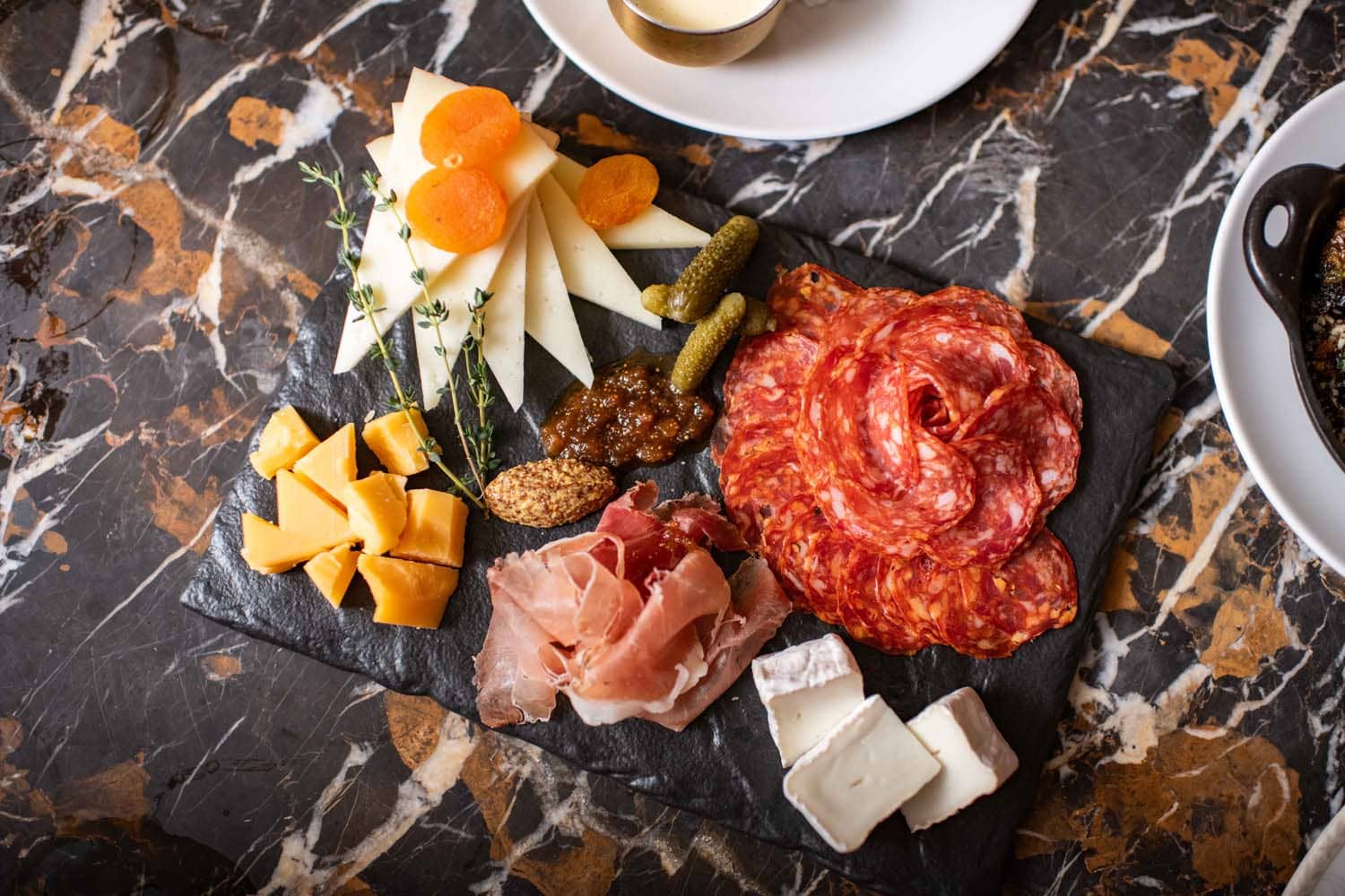 A spread of cheeses and meats on a table at The Raleigh Room