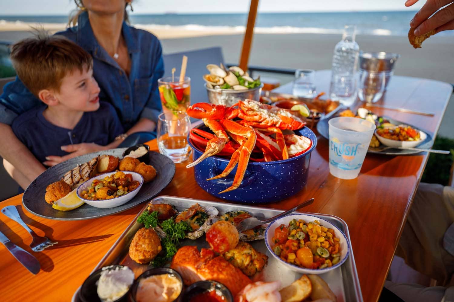 A variety of plated seafood dishes on a table at The Deck Seaside Bar & Grill