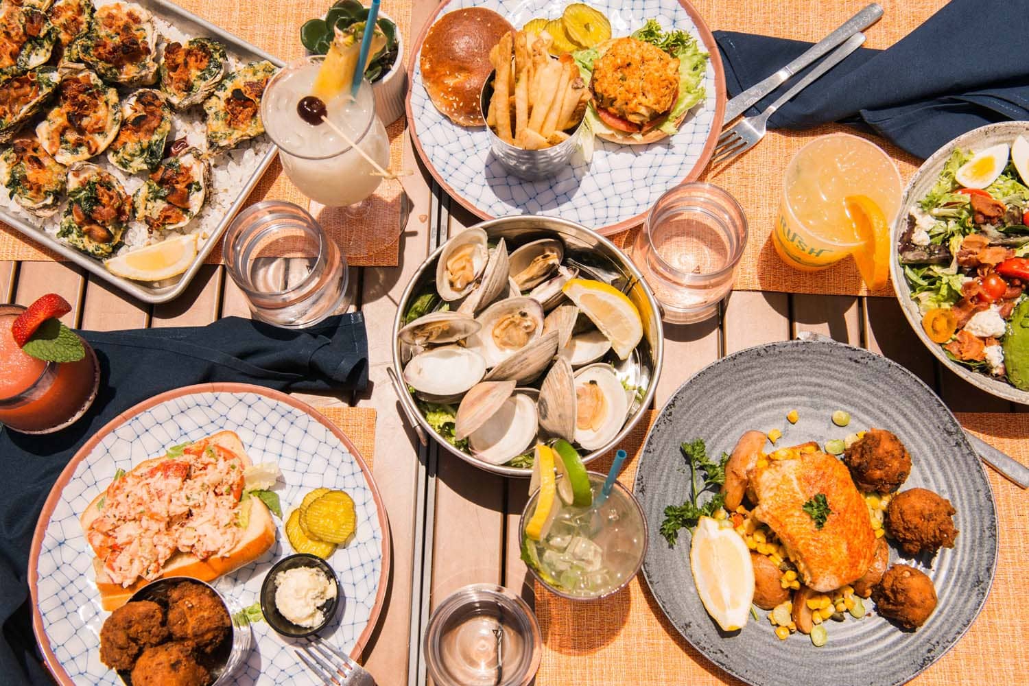A variety of plated seafood dishes on a table at The Deck Seaside Bar & Grill