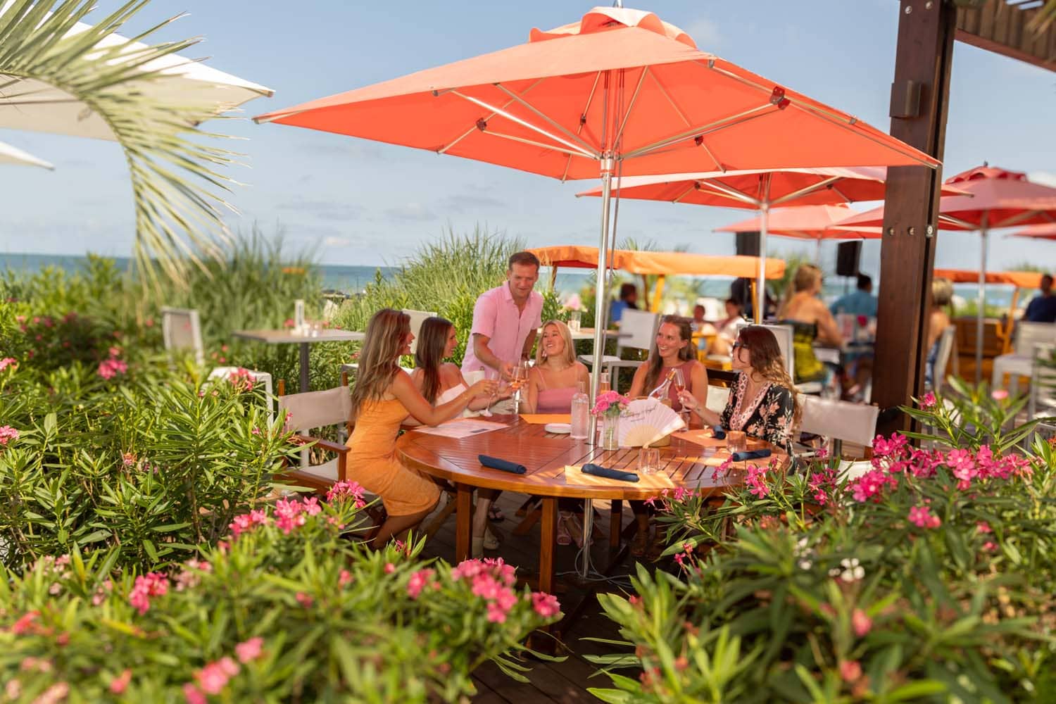 An outdoor patio with flowers and greenery at The Deck Seaside Bar & Grill