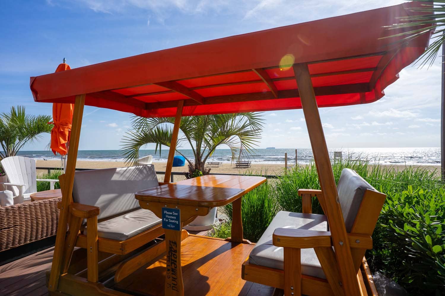The view and tables with ocean backdrop at The Deck Seaside Bar & Grill