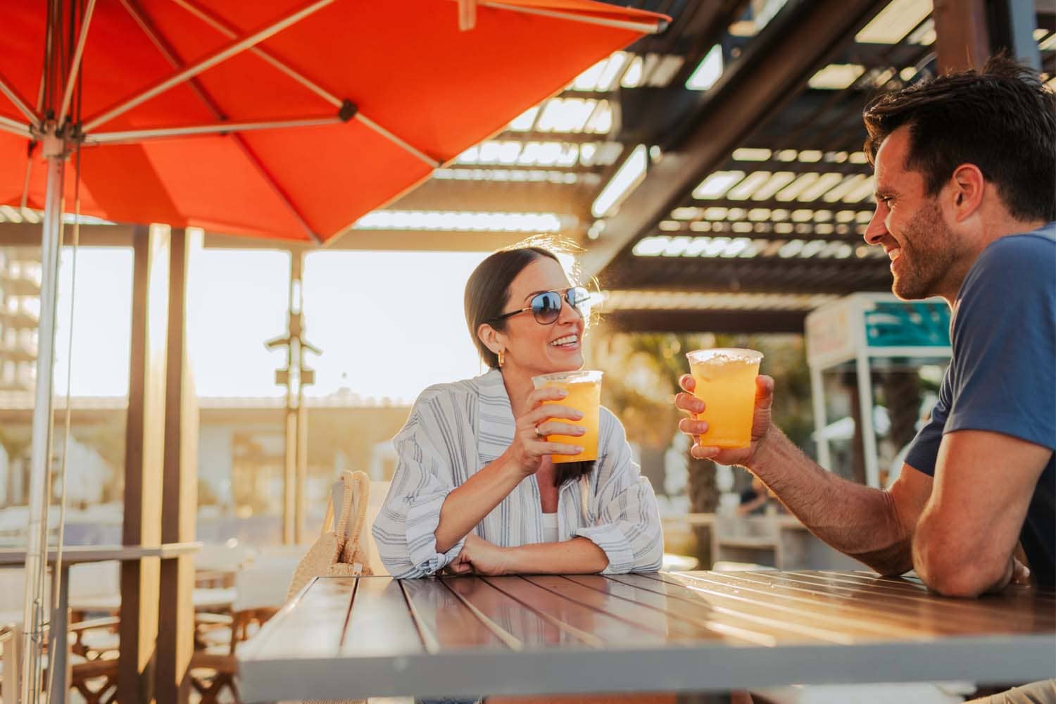 A couple sharing sunset drinks at The Deck Seaside Bar & Grill