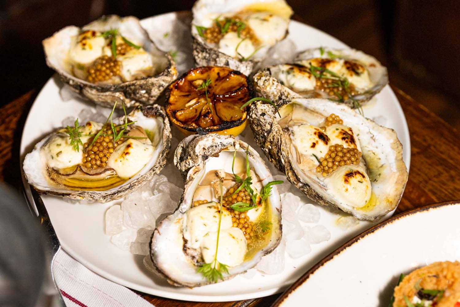 A close-up view of an oyster appetizer on a table at the Hunt Room