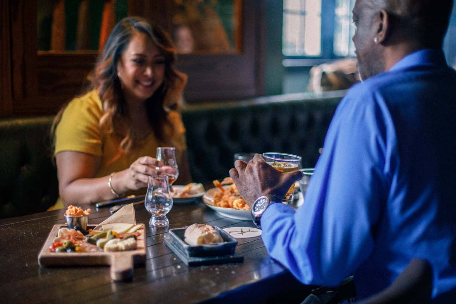 A couple sharing a meal and drinks at the Hunt Room