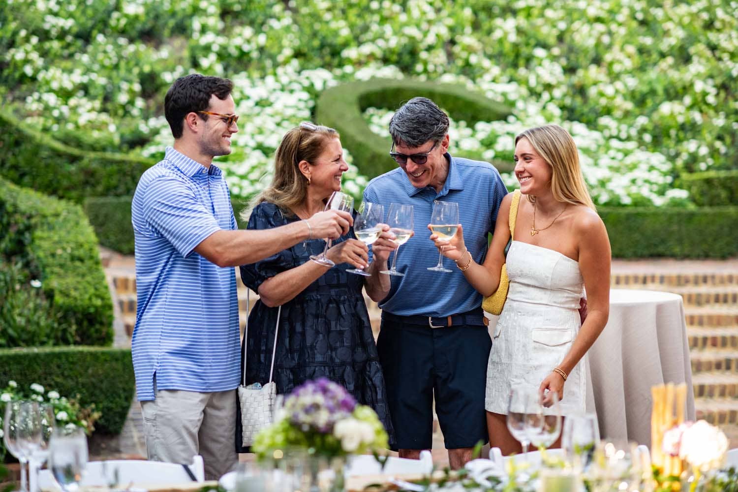 A family sharing white wine in the sunken garden at The Historic Cavalier Hotel