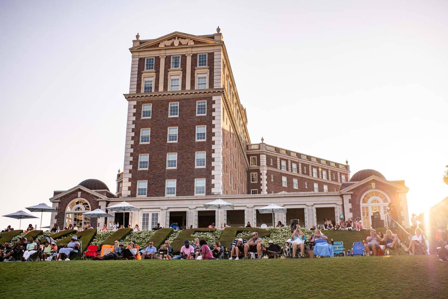 The Historic Cavalier Hotel Great Lawn with people sitting in chairs at sunset