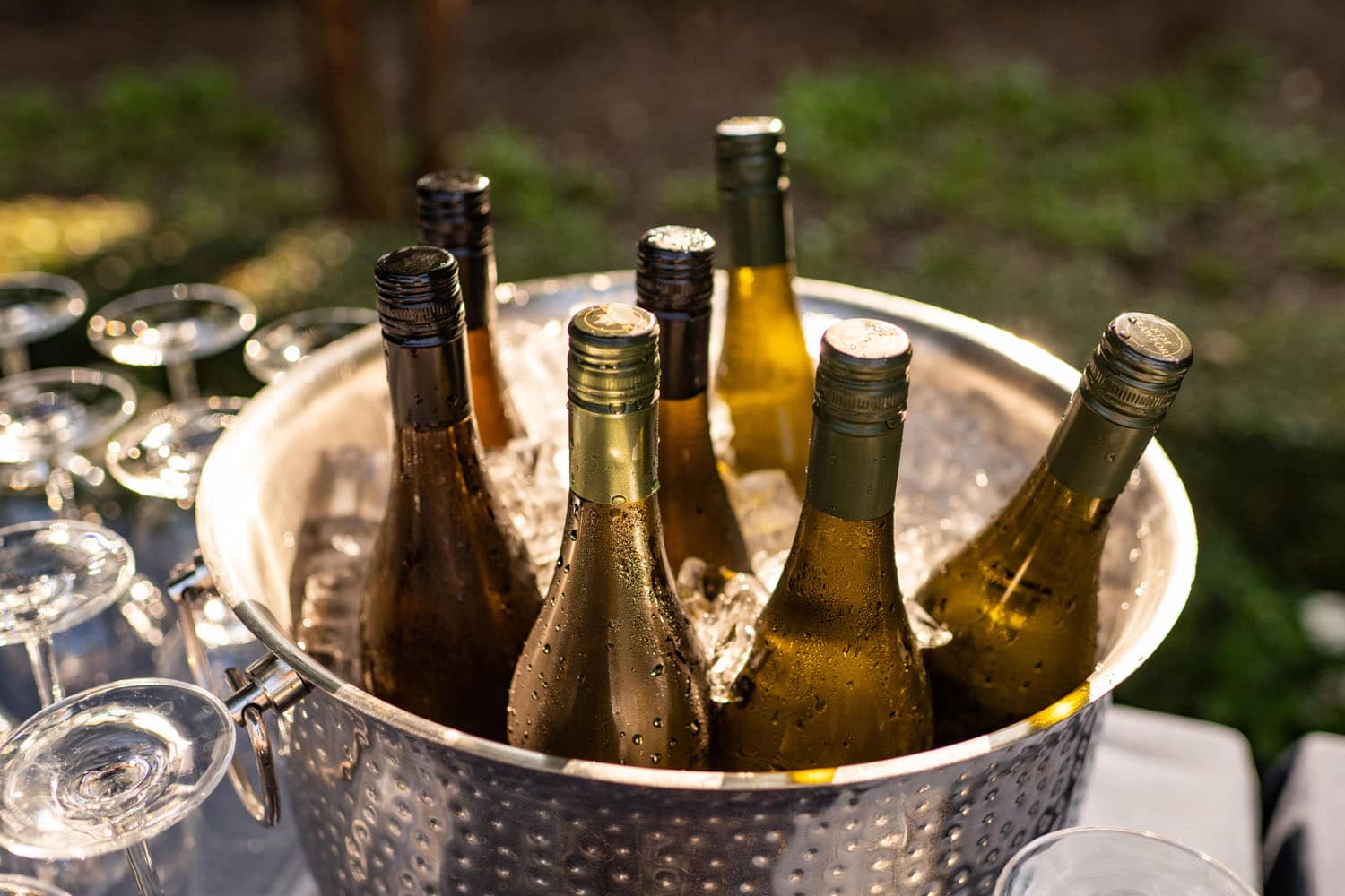 A large bowl filled with ice and white wine bottles on a table